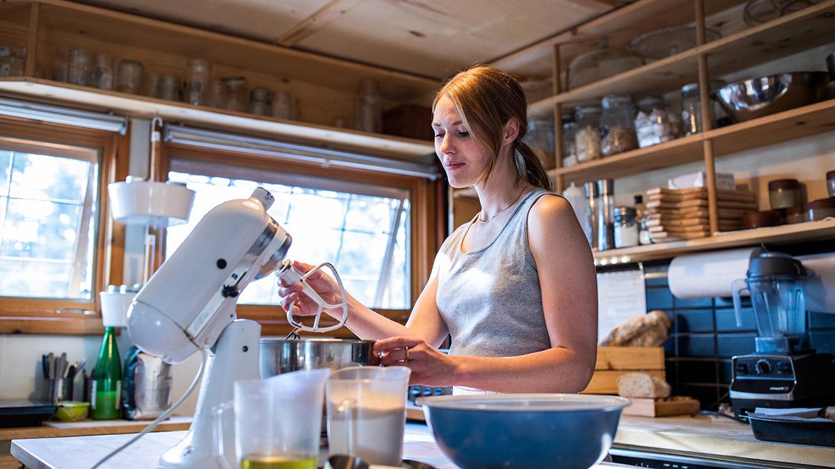 A person in the kitchen using a mixer