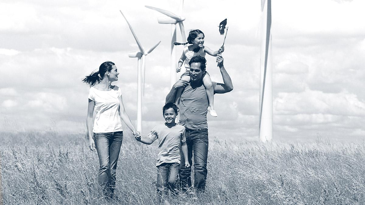 Family in a field with wind turbines